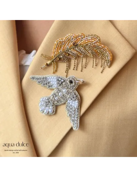 Aqua Dulce Feather 7067 på en blazer – stylingfoto; fuglebrochen medfølger ikke